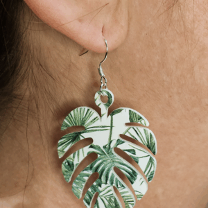 Monstera leaf acrylic earring with green tropical print shown worn on ear.