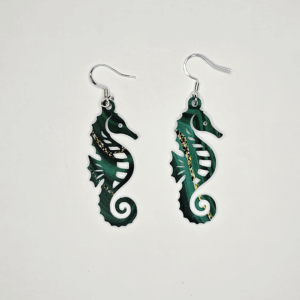 Acrylic seahorse earrings in marbled teal with gold accents displayed on white background.